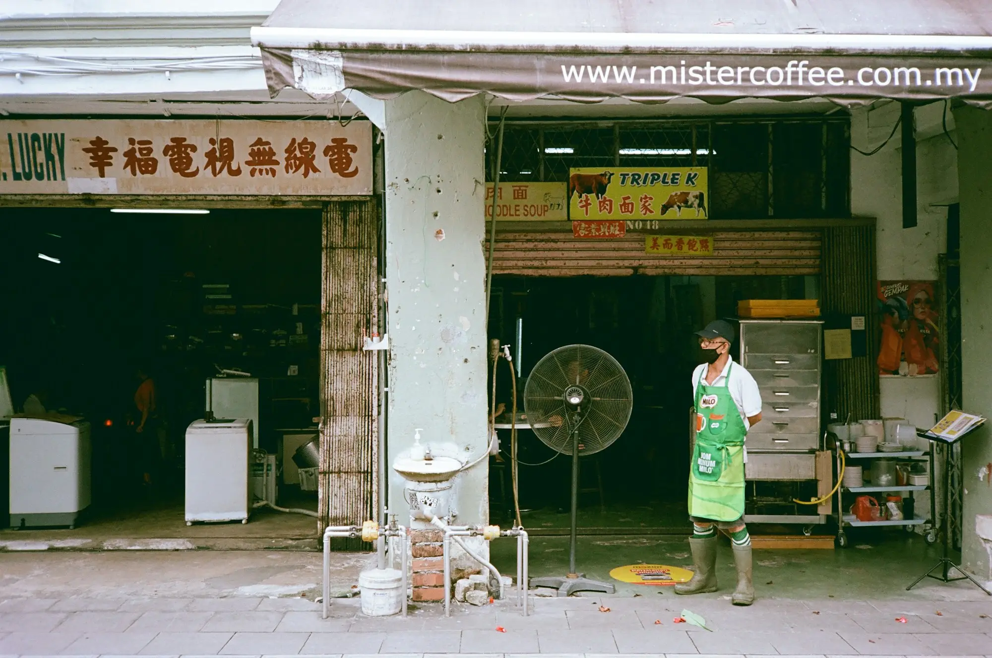 Owner standing outside an appliance shop, the kind of established business people buy with acquisition funding